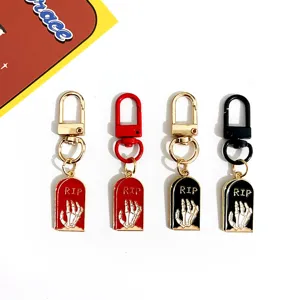 Halloween metal keychain with tombstone and skeleton hand design, spooky bag charm accessory.