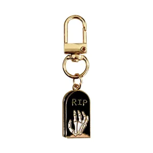 Halloween metal keychain with tombstone and skeleton hand pendant, stylish bag accessory.