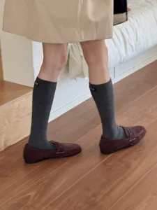 Details of grey calf socks with small label paired with loafers. Comfortable knit daily wear.