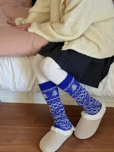 Cozy blue and white Fair Isle knit stirrup leg warmers detail for winter warmth and style.