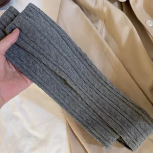 Grey cable knit over-the-knee socks for women, soft texture, cozy winter accessory detail.