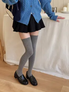 Grey over-the-knee socks detail shot, cozy autumn winter college style hosiery wear look.