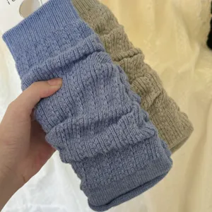 Close-up of cable knit leg warmers showing soft textured fabric and elastic fit details.