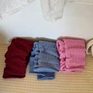 Detailed shot of cozy cable knit leg warmers in three solid colors, soft texture.