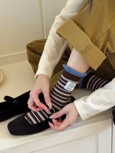 Close-up view of brown striped mid-tube socks featuring a cute puppy embroidery patch design.