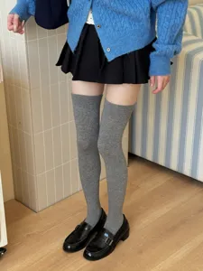 Grey over-the-knee socks detail shot, soft knitted fabric, stylish college look for daily wear.