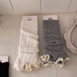 Close-up detail of cozy knitted leg warmers with delicate lace trim, comfortable texture.