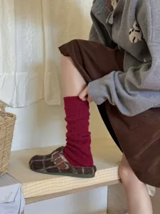 Knit leg warmers detail view, wine red slouchy aesthetic design for cozy winter wear.