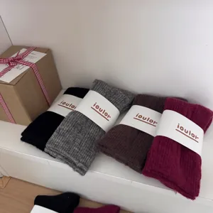Cozy knit tube socks set in versatile solid colors, neatly packaged with stylish paper bands.