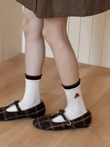 Detail shot showing cute embroidered cartoon dog cotton mid-calf socks paired with shoes.