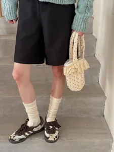 Detail view of combed cotton stacked socks paired with vintage sneakers and casual outfit.