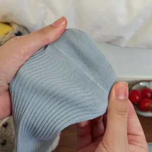 Close-up detail of light blue ribbed knit fabric, soft texture and fine workmanship.