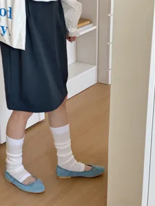 Detail shot of white layered footless socks with blue flats and skirt, perfect for style.