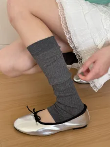 Grey stirrup leg warmers knitted slouch socks paired with silver ballet flats for trendy outfits.