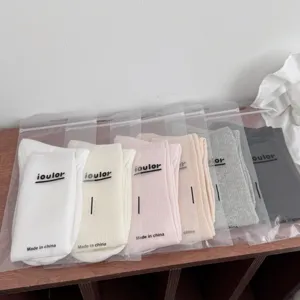 Close-up view of thin breathable women slouch long socks in transparent packaging bags detail.