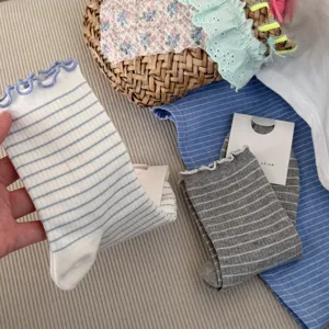 Detailed view of women's sweet ruffled striped mid-calf cotton socks, soft texture.