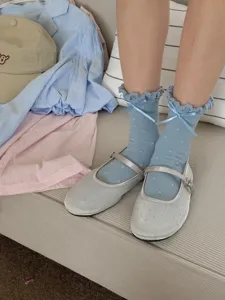 Cute blue frilly mid-calf socks with sweet bows and polka dots, paired with stylish silver shoes.