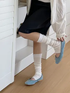 Detailed view of Korean style solid white stirrup leg warmers, versatile fashion stacked socks.