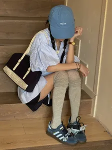 Styling detail shot featuring comfortable ribbed over-the-knee socks paired with casual footwear.