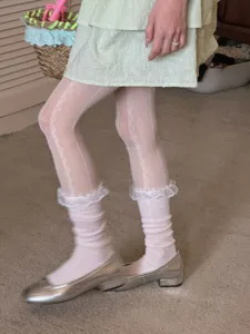 Close-up detail of sweet lace ruffle stack socks paired with white tights for a cute outfit look.
