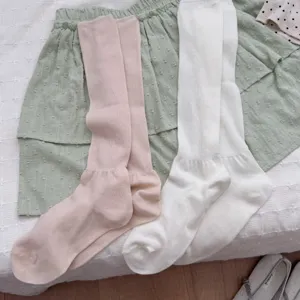 Detailed view of women's thin slouch long socks in pink and white, lightweight spring style.