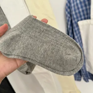 Close-up view of grey ribbed cotton blend tights fabric showing soft and breathable texture.