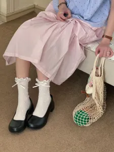 Detail view of cute lettuce edge polka dot mid-calf socks with sweet bow knots for women.