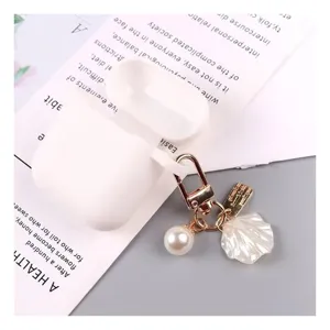 Pearl shell keychain with gold clasp and white protective case accessory for daily bag charm.