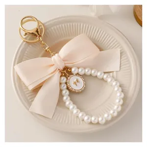 Close-up detail of the elegant pearl bow keychain showcasing delicate ribbon and shiny pearls.