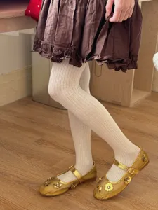Detailed view of women's comfortable ribbed pantyhose paired with stylish gold flat shoes.