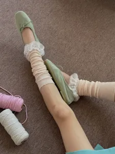 Sweet Japanese style lace ruffle leg warmers paired with green ballet flats for women.