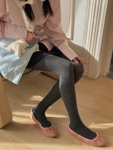 Detailed view of women grey ribbed tights paired with pink flat shoes and sweet style outfit.