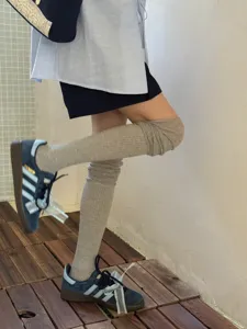 Grey over-the-knee slouch socks paired with stylish retro sneakers for women, perfect for daily fashion.