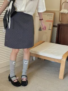 Detailed closeup view of stylish grey ribbed leg warmers featuring cute patch design.