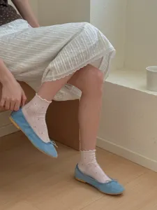 Detail shot of women's sheer short socks featuring sweet ruffled lace edges and delicate dotted patterns.