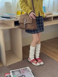 Dettaglio scaldamuscoli bianchi in maglia chic, consistenza morbida e design elegante da indossare.