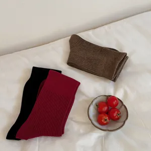 Solid color ribbed knit long socks detail view, cozy aesthetic style women winter hosiery.