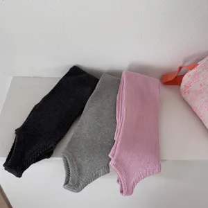 Vista dettagliata di scaldamuscoli con staffa lavorati a maglia in tre colori su ripiano.