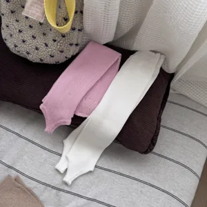 Dettaglio scaldamuscoli in maglia con staffa rosa e bianco, stile chill coreano accogliente.