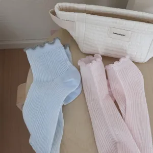 Detailaufnahme von atmungsaktiven Rüschen-Mesh-Mittelsocken in Hellblau und Rosa.