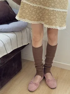Dettaglio di scaldamuscoli in maglia marrone stile coreano, outfit quotidiano e comodo.