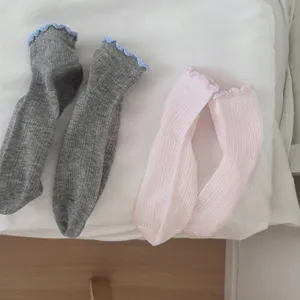 Nahaufnahme von Damensocken in mittellanger Passform mit feiner Spitzenborte und Strick.