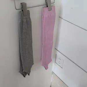Dettaglio scaldamuscoli in maglia con staffa, appesi a una clip metallica, accoglienti.