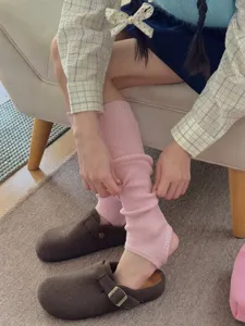 Dettaglio scaldamuscoli a staffa a coste rosa, stile calze in maglia accogliente per outfit.