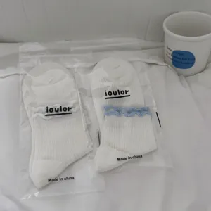 Nahaufnahme Detailansicht weiße Mesh Damen Socken mit Spitzenbesitz im Klarsichtbeutel.