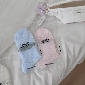 Nahaufnahme von atmungsaktiven Mesh-Socken mit kontrastfarbener Spitzenborte in Verpackung.