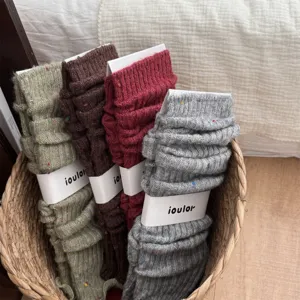 Dettaglio di scaldamuscoli spessi in cashmere maculato IOULOR in accoglienti colori autunnali.
