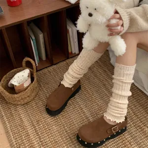 Primo piano di scaldamuscoli accoglienti e maculati abbinati a scarpe con plateau.