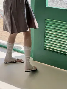 Detailed shot of breathable summer stacked socks with ruffled cuffs worn with sandals.
