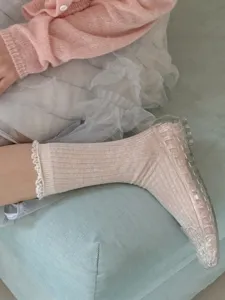 Gros plan détaillé de chaussettes mi-hautes tricotées style japonais avec bordure en dentelle.